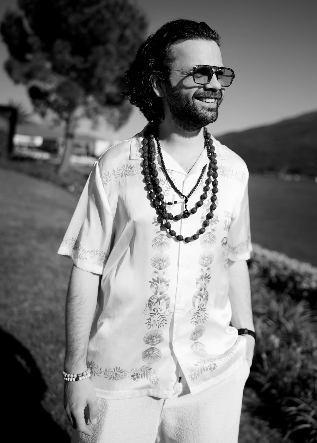Prohor outdoors in a loose patterned outfit, photographed in black and white